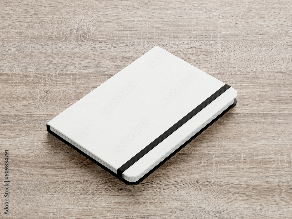 White moleskine isolated on the wooden background White moleskine isolated on the wooden background