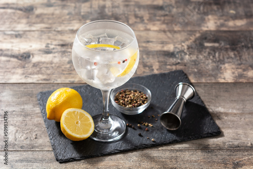 Gin tonic cocktail drink into a glass on wooden table