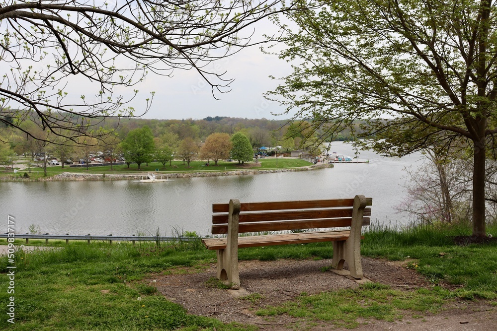 The empty park bench overlooking the lake in the park. The empty park bench overlooking the lake in the park.