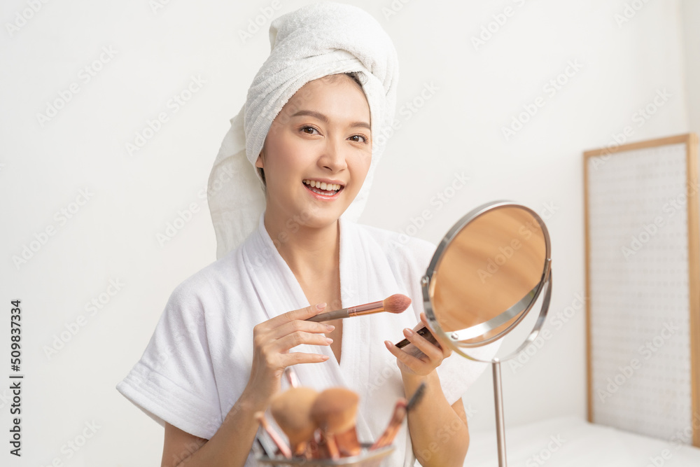 Happy beauty blogger concept, cute asian young woman, girl smile, make up face by applying brush blush powder on her cheek, looking at the mirror. People look with natural fashion style. Happy beauty blogger concept, cute asian young woman, girl smile, make up face by applying brush blush powder on her cheek, looking at the mirror. People look with natural fashion style.