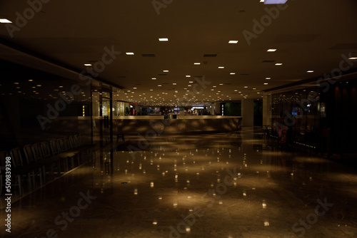 Fototapeta Mall, lights from the ceiling are reflecting on the shiny floor.