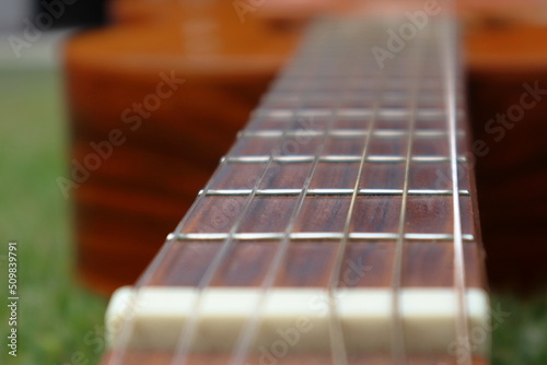 Acoustic guitar close-up detail of fretboard and strings under the sunlight