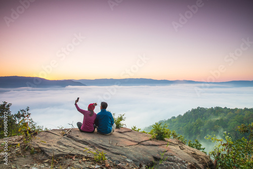 The lover hiking on high mountain with sea of mist at Phong-fan, Loei province Thailand.