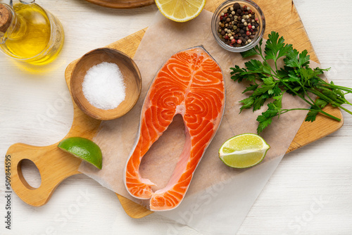 Overhead view of Raw salmon steak and vegetables on light surface fish food cooking