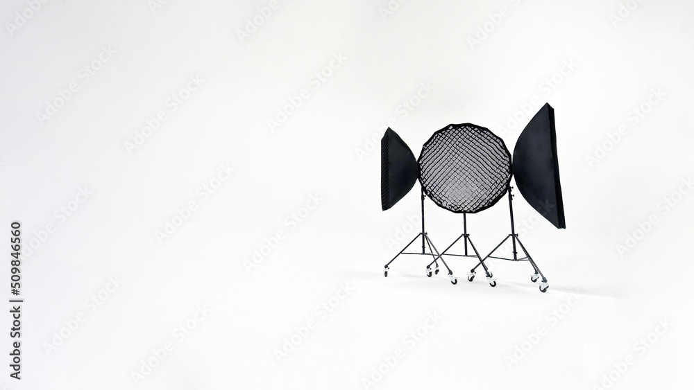 Three studio lights of softbox and octobox stand against background of white cyclorama in photostudio Three studio lights of softbox and octobox stand against background of white cyclorama in photostudio