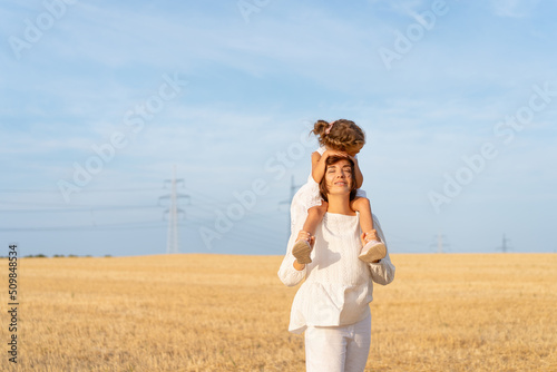 Принти на полотні Little girl sitting mother shoulders hug her head