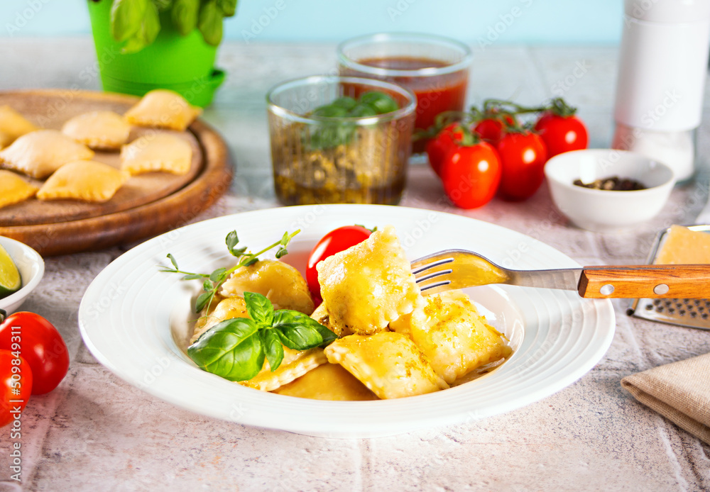 Homemade traditional italian ravioli pasta with basil and tomato cherry vegetables on the table