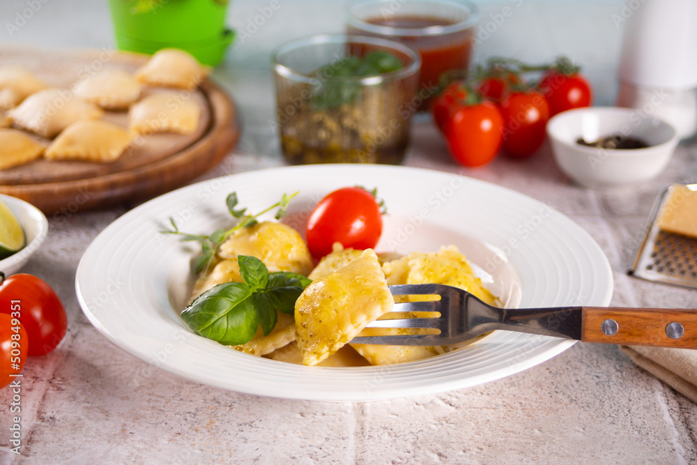 Homemade traditional italian ravioli pasta with basil and tomato cherry vegetables on the table Homemade traditional italian ravioli pasta with basil and tomato cherry vegetables on the table