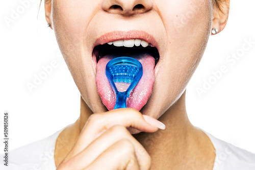 Close Up Mund, weibliches Model putzt sich die Zunge mit einem Zungenreiniger, frontal