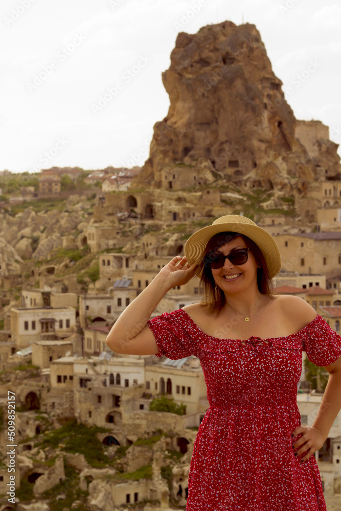 happy woman in a hat on the terrace in cappadocia, turkey	