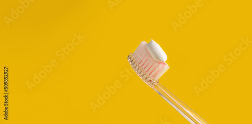 Brush with toothpaste on yellow background  space for text. Banner design