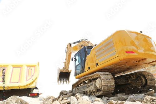 Excavator on earthworks at construction site. Backhoe on foundation work and road construction. Heavy machinery and construction equipment. Excavator under building