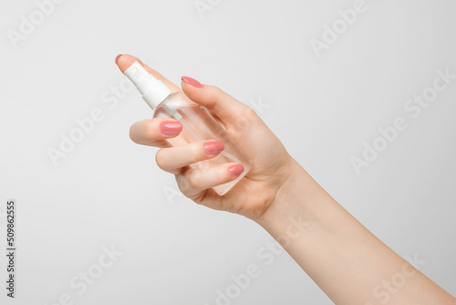 Woman holds alcohol-based hand sanitizer spray as a preventive measure against virus and bacteria.