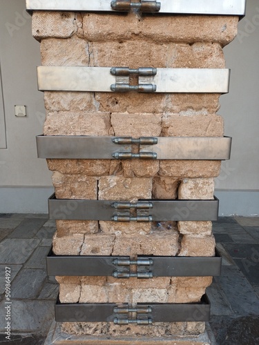 Fotografia Metal steel clamps adjusted in column to improve its structural stability