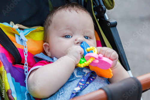 beautiful little boy in a stroller with a pacifier