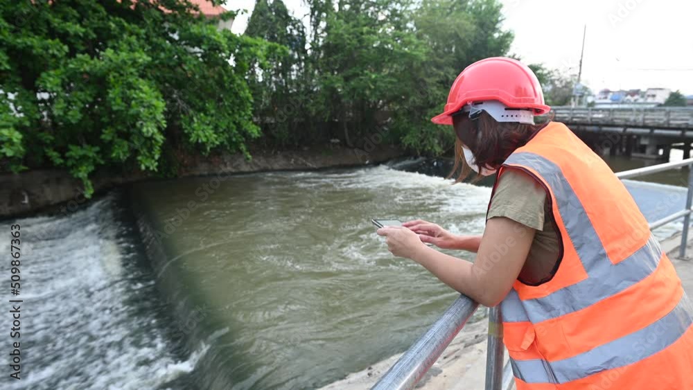 Asian Female engineering working
at sewage treatment plant,Marine biologist analysing water test results,World environment day concept Asian Female engineering working
at sewage treatment plant,Marine biologist analysing water test results,World environment day concept