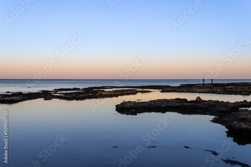 Sunrise reefs at the beach in Acre, birds and fishermen