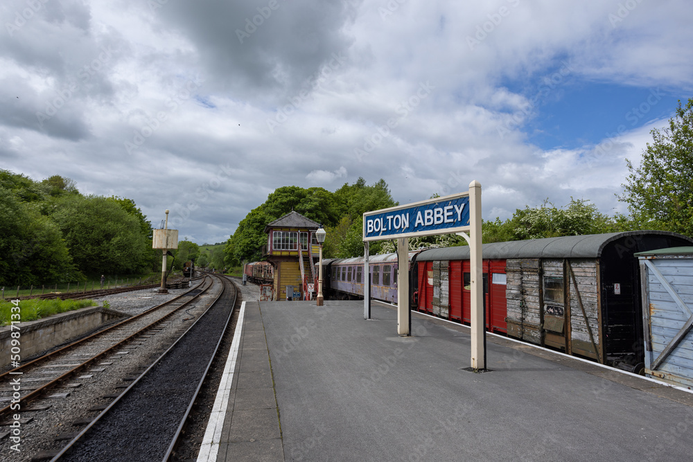 Bolton Abbey sign at platform between train rails and old wooden train ...