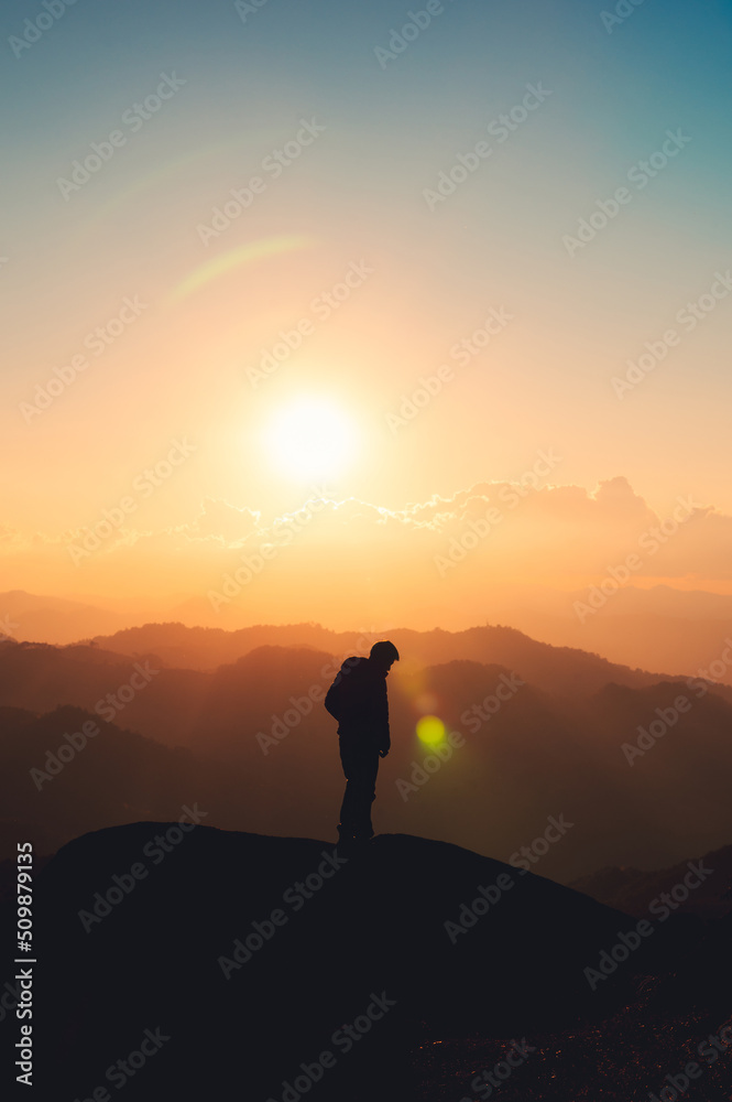 Hiker man standing on top of mountain enjoying the beautiful sunset in national park