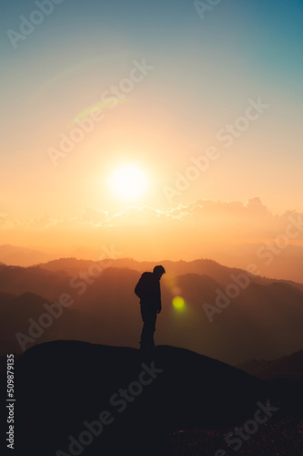 Hiker man standing on top of mountain enjoying the beautiful sunset in national park