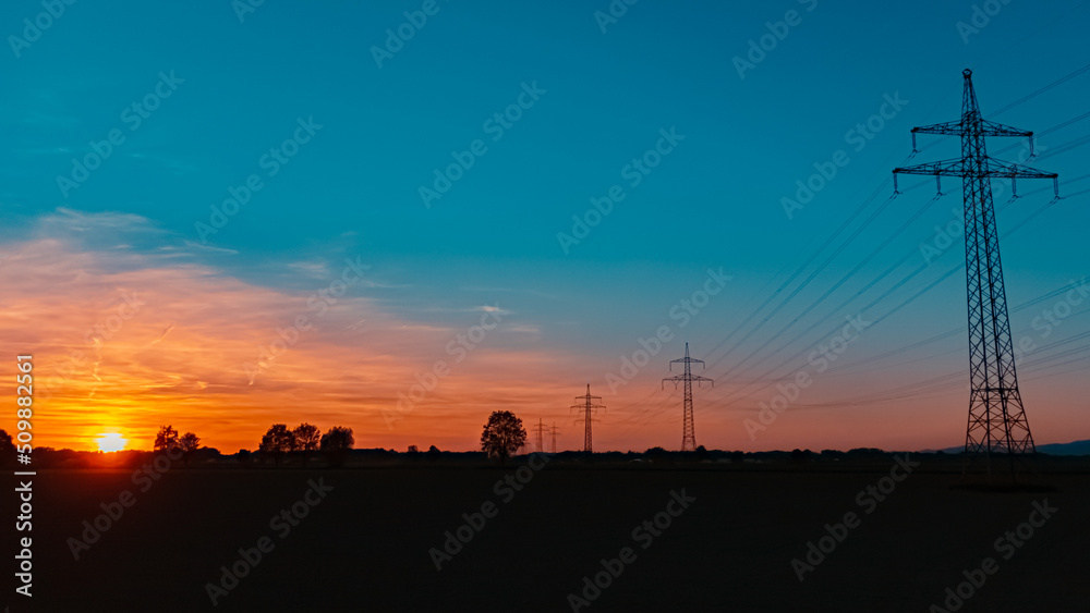 Obraz premium Beautiful sunset with a dramatic sky and overland high voltage lines near Tabertshausen, Bavaria, Germany