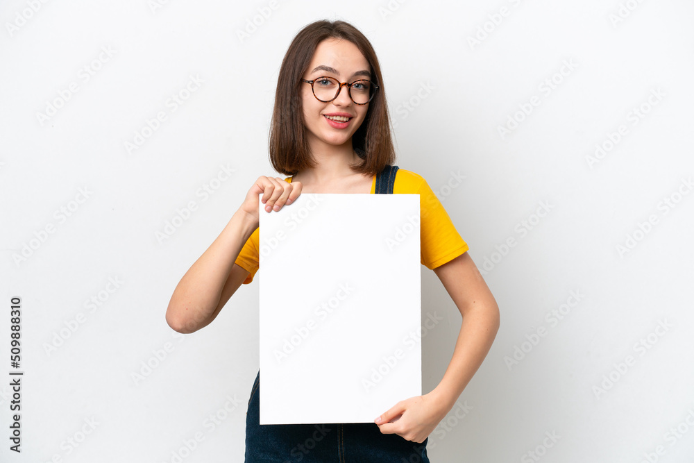 Young Ukrainian woman isolated on white background holding an empty placard with happy expression Young Ukrainian woman isolated on white background holding an empty placard with happy expression