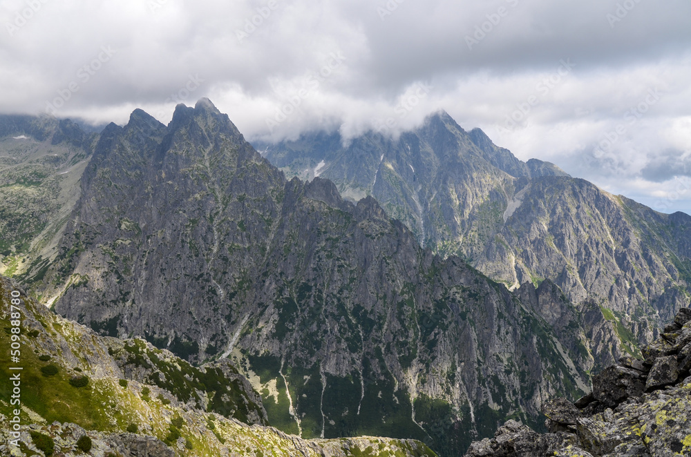Rocky peaks of High Tatras mountain range under low clouds, view from Slavkovsky Stit, Slovakia 
