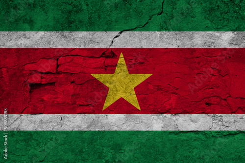 Patriotic cracked wall background in colors of national flag. Suriname