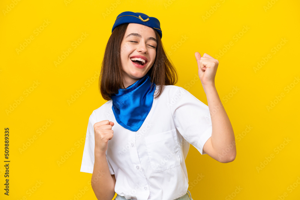 Airplane stewardess Ukrainian woman isolated on yellow background celebrating a victory Airplane stewardess Ukrainian woman isolated on yellow background celebrating a victory