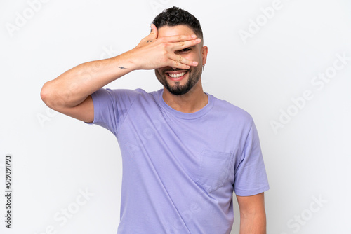 Young Arab handsome man isolated on white background covering eyes by hands and smiling