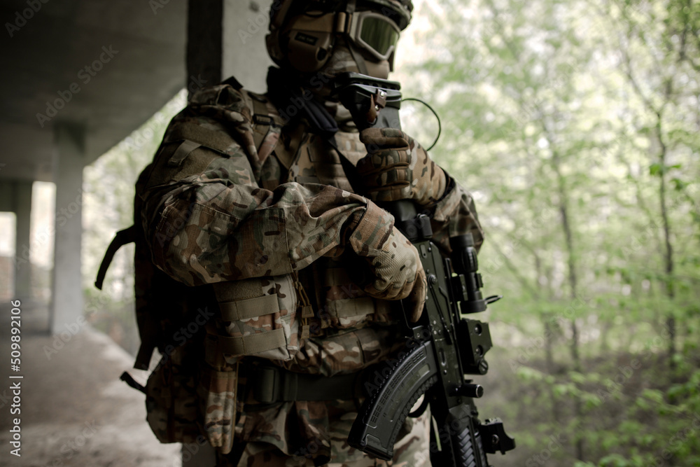 Military soldier in uniform standing with a weapon in his hands