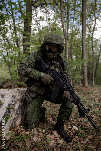 Military soldier in uniform sitting in the forest, vertical photo