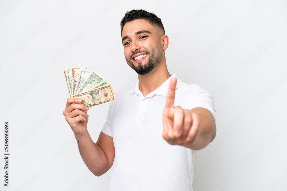 Young Arab man taking a lot of money isolated on white background showing and lifting a finger Young Arab man taking a lot of money isolated on white background showing and lifting a finger