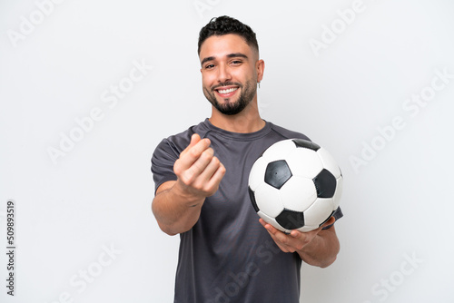 Arab young football player man isolated on white background making money gesture © luismolinero
