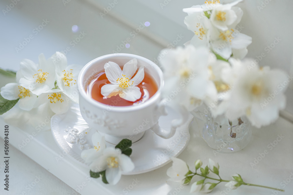 Spring still life with a cup of tea and jasmine flowers Spring still life with a cup of tea and jasmine flowers