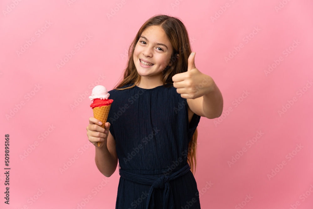 Child with a cornet ice cream over isolated pink background with thumbs up because something good has happened Child with a cornet ice cream over isolated pink background with thumbs up because something good has happened