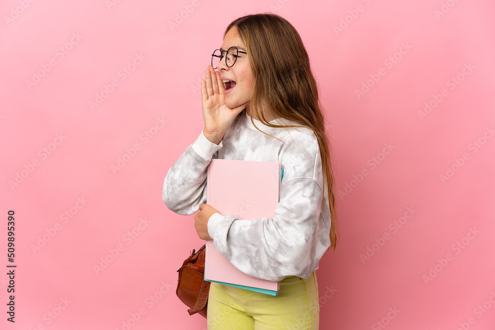 Student little girl over isolated pink background shouting with mouth wide open to the side Student little girl over isolated pink background shouting with mouth wide open to the side