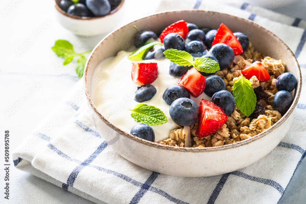 Healthy breakfast. Yogurt with granola and fresh berries at white table. Healthy breakfast. Yogurt with granola and fresh berries at white table.