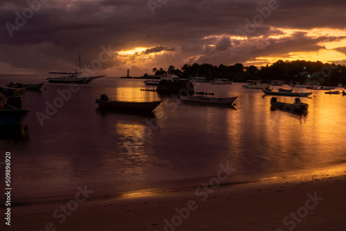 Purple sunset on a river beach full of fishing boats in Itacaré