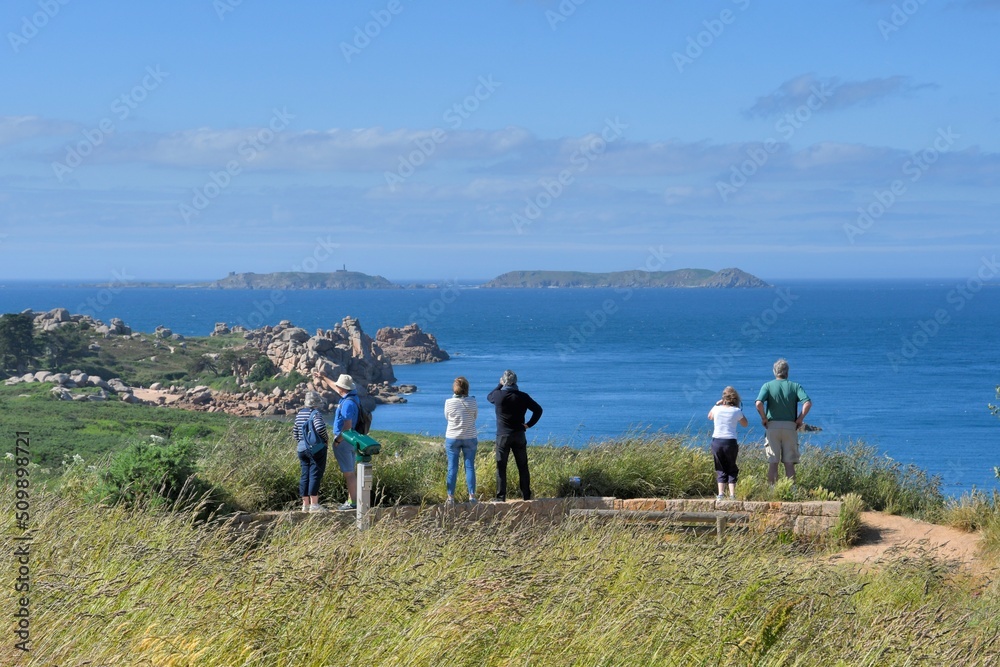 Group of tourists watching the sea on the pink granite coast in Brittany-France