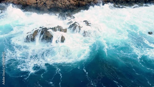Sea waves washes the rocky shore, Above Aerial shot, Flying Over Coastline, Cliffside with Blue Pure Water, Ocean During Sunny weather. Bird Eye View 4K Cinematic Drone Footage, Cyprus