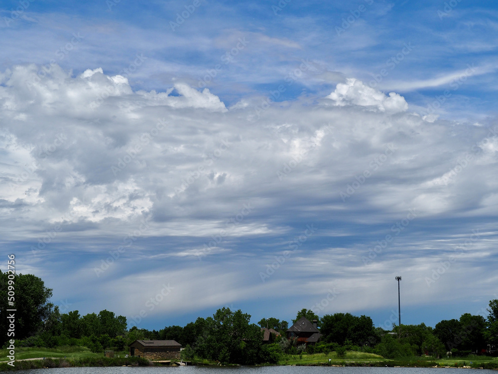 Developing thunderstorm with altocumulus clouds in the foreground. Summer thunderstorm over a Wichita lake. 