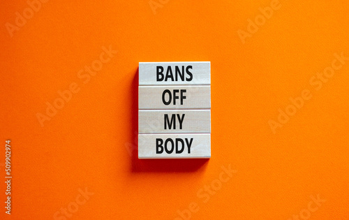 Bans off my body symbol. Concept words Bans off my body on wooden blocks on a beautiful orange table orange background. Women rights concept. Business social issues and bans off my body concept.