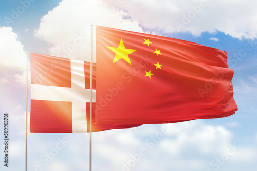 Sunny blue sky and flags of china and denmark
