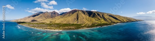 Aerial panorama drone view of the West Maui Mountains along west coast of Maui with clear blue ocean water and coral reef and green mountain on the background. Maui, Hawaii © Lucas