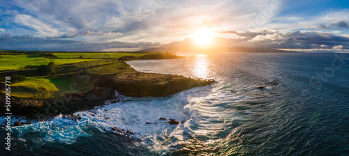 Aerial panorama view of the North Shore of Maui on the coast with clear blue ocean and big waves crashing on rocks at sunset. Maui, Hawaii © Lucas