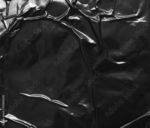 black crumpled and creased plastic poster texture background
