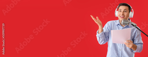 Male radio presenter with microphone on red background with space for text photo