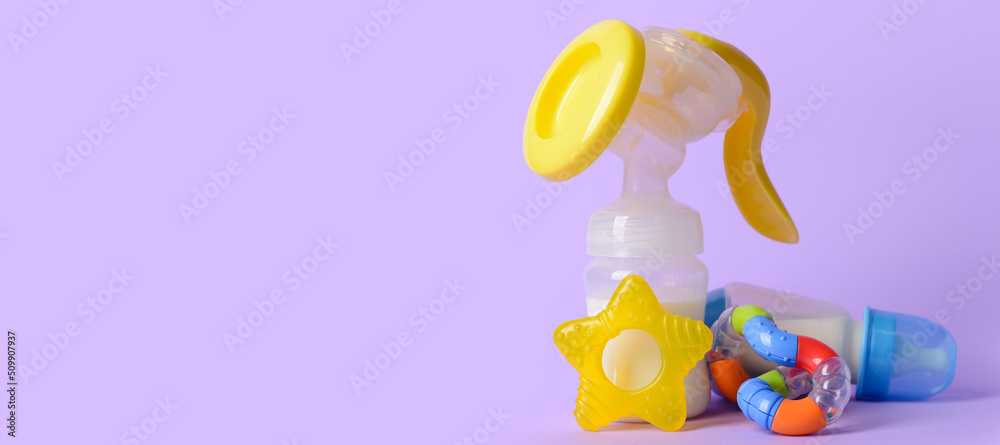 Breast pump with bottles of milk and baby accessories on lilac background with space for text