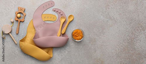 Konstfotografi Silicone baby bibs with plastic cutlery, food and toys on grunge background with